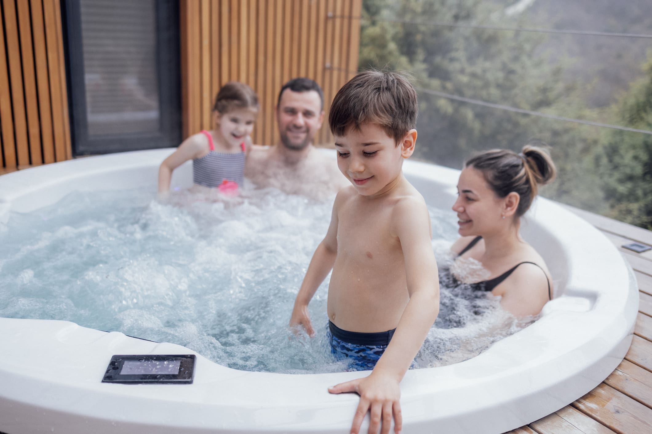 Happy family with two small children have fun in the hot tub Family playing in clean Hot tub